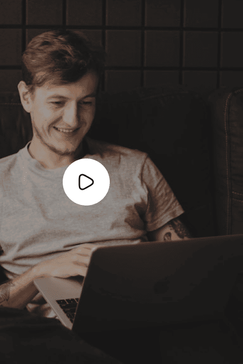Man smiling at a laptop in a dark room, email marketing video thumbnail